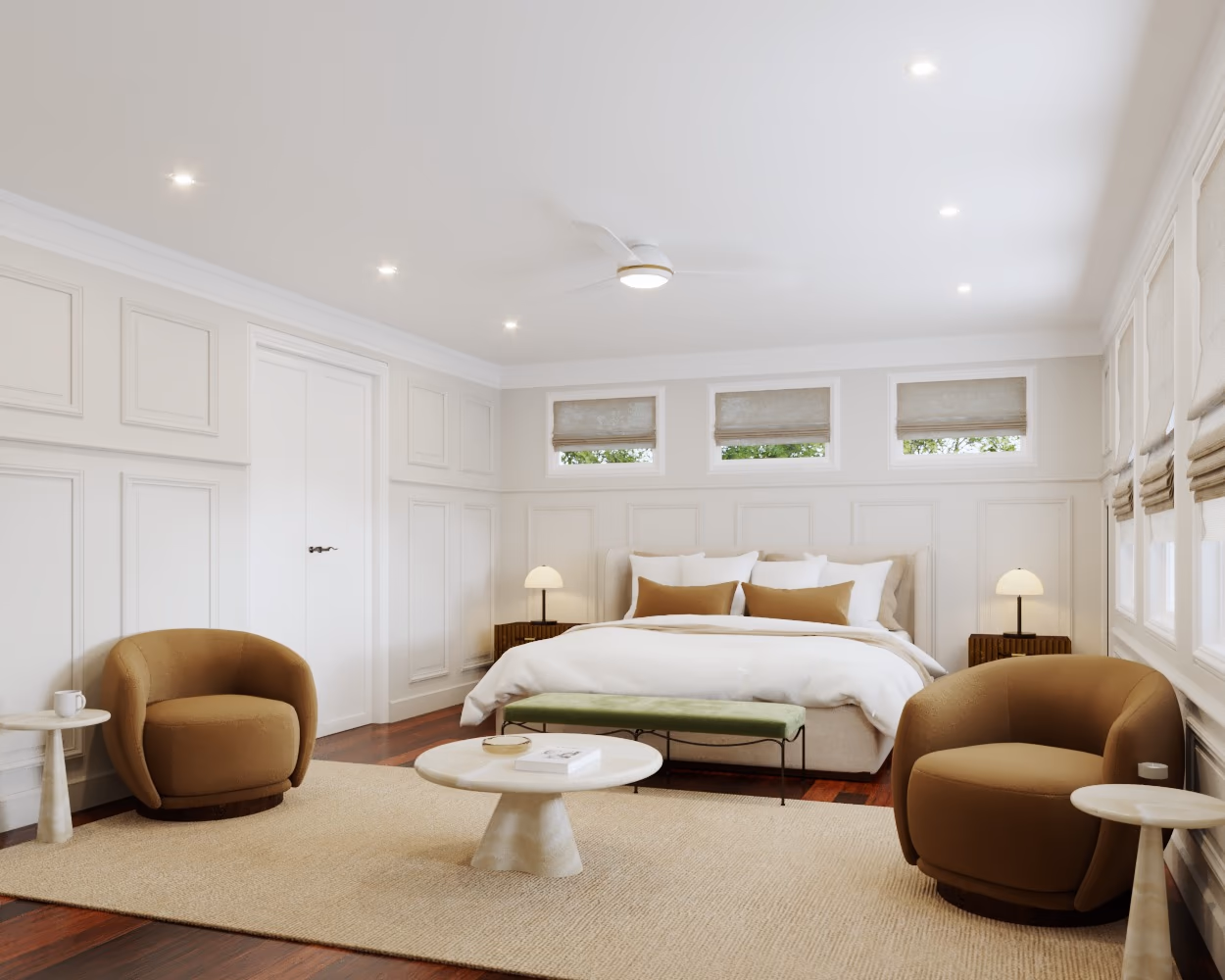 Primary bedroom with paneled white walls, cognac swivel chairs, a round coffee table, and a green bench at the foot of the bed.