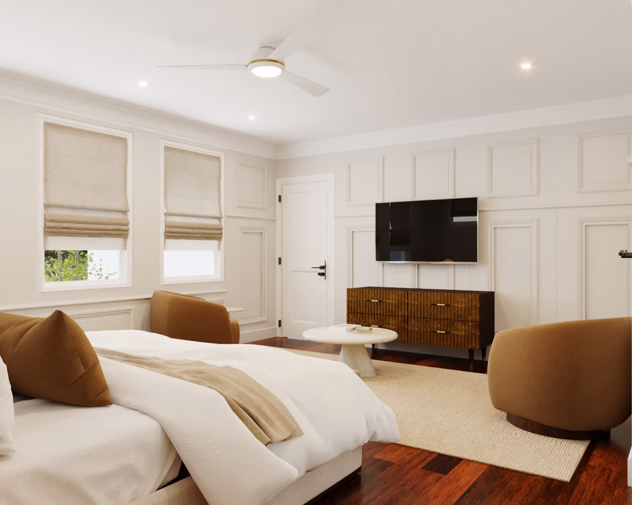 Primary bedroom sitting area with swivel chairs, a walnut dresser, and a wall-mounted TV.