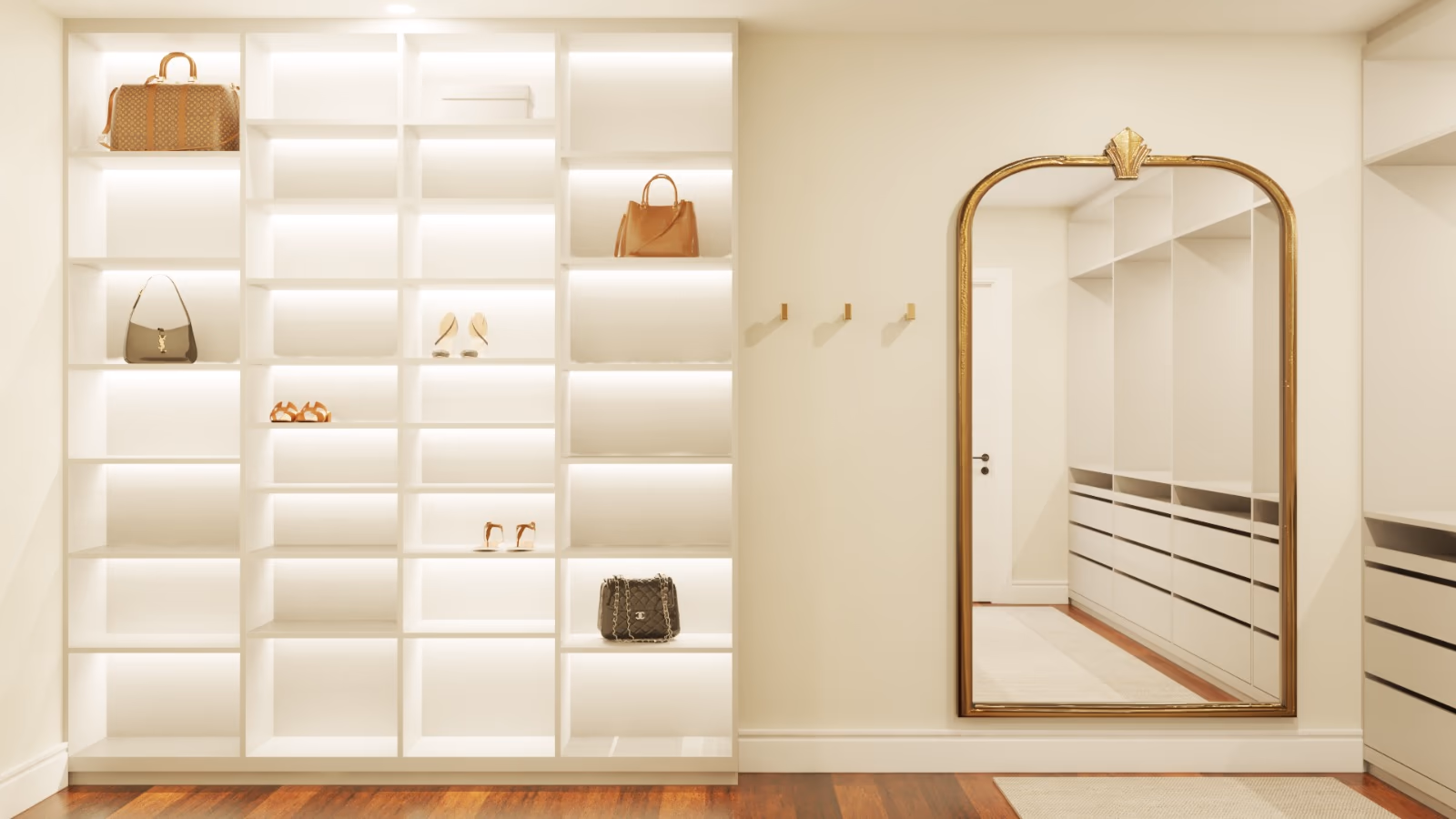 Walk-in closet with lit white shelving for handbags and shoes and a brass arched mirror.