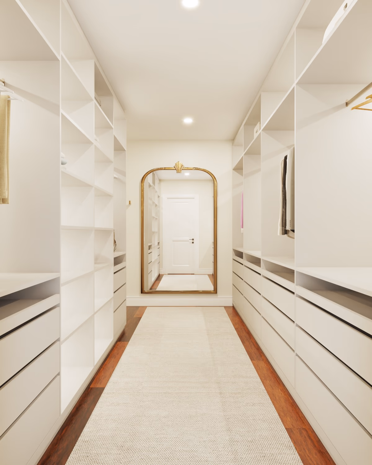 Walk-in closet corridor lined with white cabinetry, a runner rug, and an arched mirror at the end.