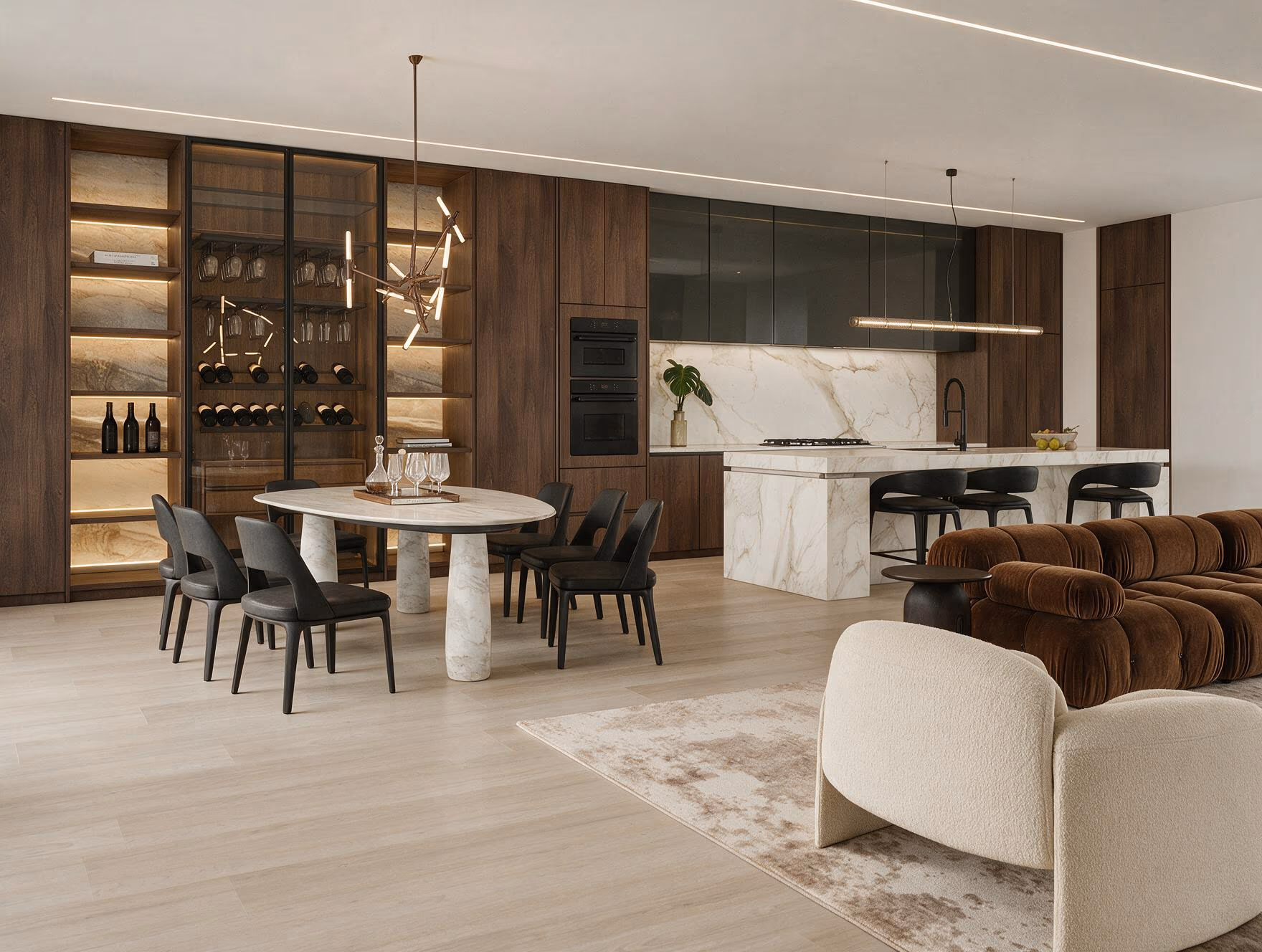 Open living, dining, and kitchen with a brown channeled sofa, a cream bouclé chair, an oval dining table, and a marble island beyond.