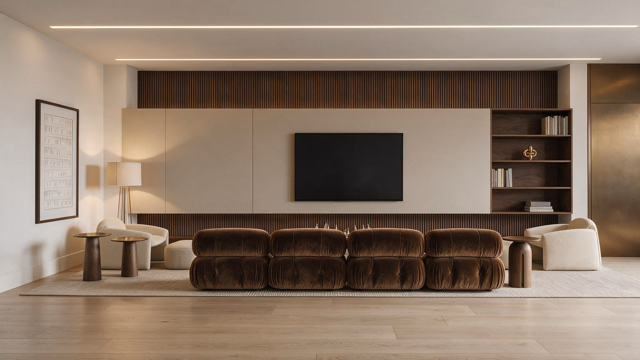 Living room with a fluted walnut media wall, a long brown channeled sofa, cream lounge chairs, and built-in shelves.